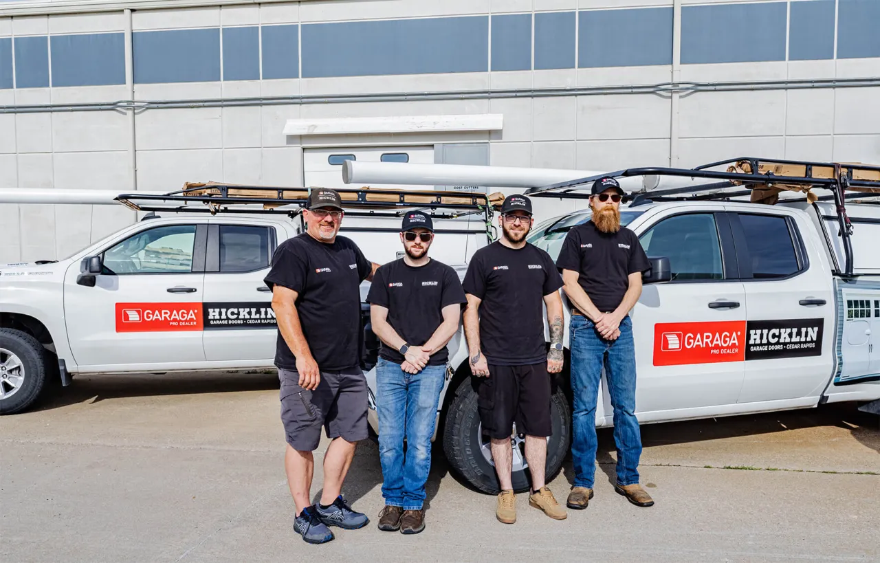 Garage door installers in front of a Hicklin Garage Door Cedar Rapids truck